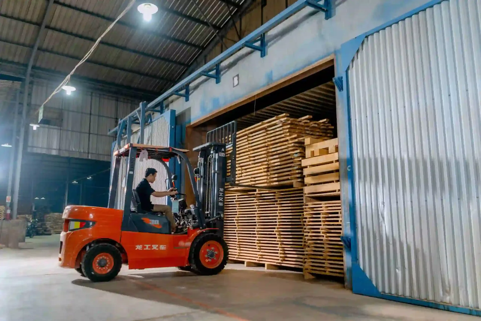 Forklift moving pallet lumber inside a warehouse